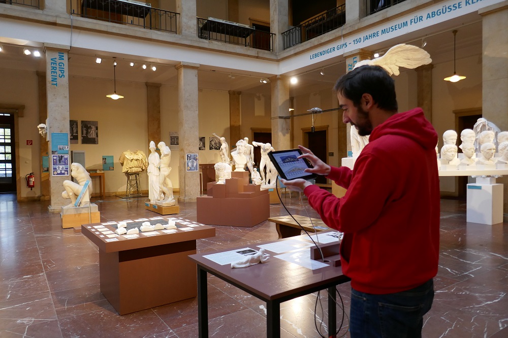 Ein junger Mann erkundet an einer Tabletstation das Museum