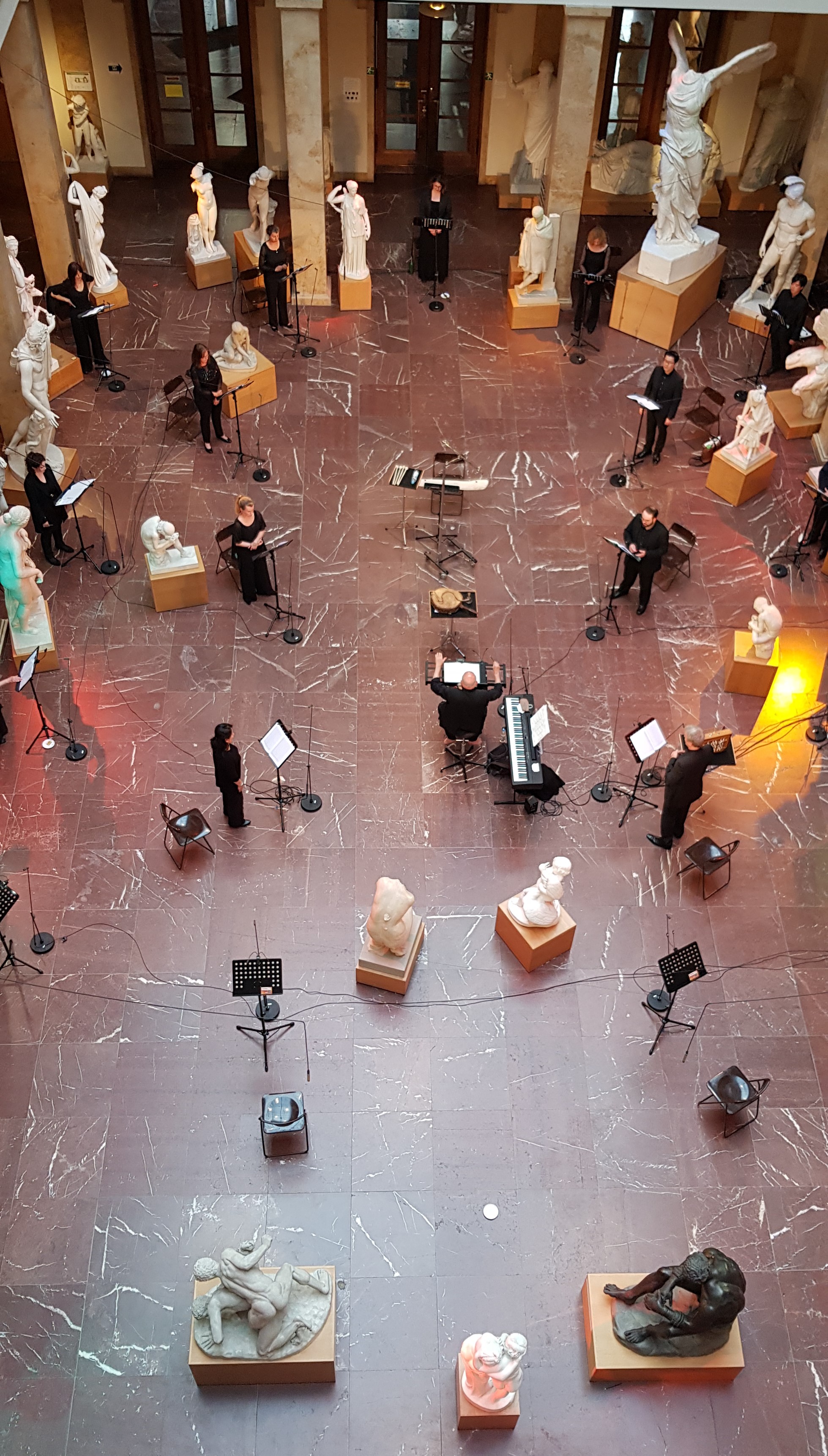 Musiker spielen ein Konzert im Lichthof und sitzen dabei verteilt im ganzen Saal zwischen den Abgüssen